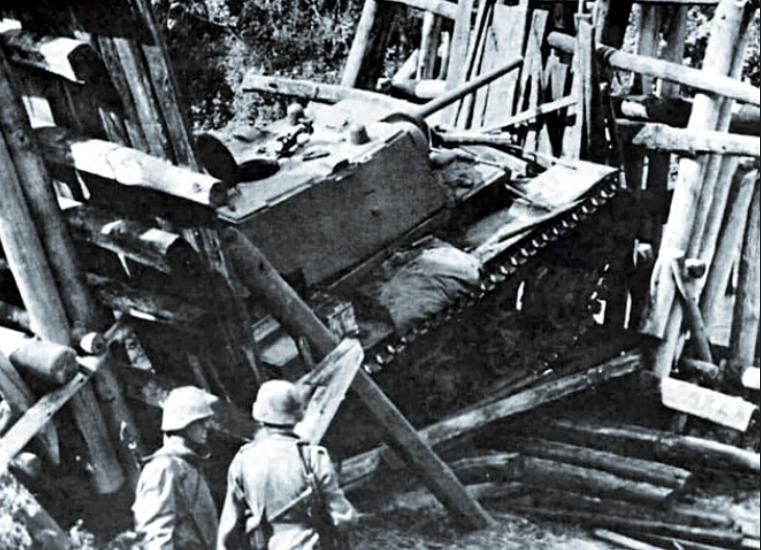 Солдаты вермахта осматривают советский танк КВ, провалившийся сквозь деревянный мост.