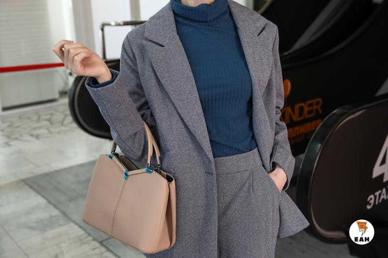    Девушка в сером костюме с сумкой