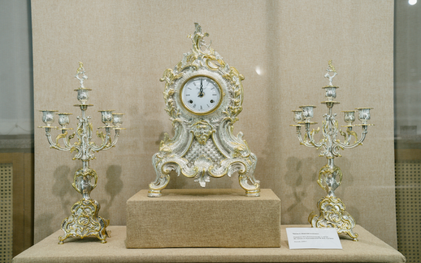 Роскошные часы с подсвечниками – подарок Михаилу Калашникову от Владимира Путина. Фото: Мария БаклановаПрезидент свое слово сдержал – 19 сентября 2013 года он встретился с Михаилом Калашниковым в День оружейника. В этот день ижевскому оружейному заводу дали имя великого конструктора.