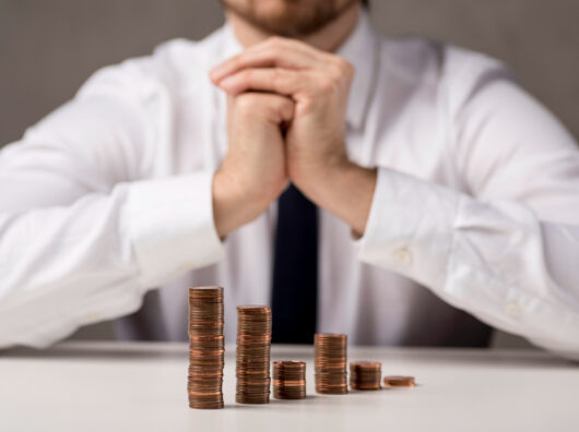    Монеты в виде графика перед бизнесменом //Фото Freepick