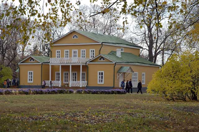 Усадьба Михаила Лермонтова в Тарханах: историческое поместье-музей с желтыми стенами, зеленой крышей и балконами, осенний парк с золотой листвой. 