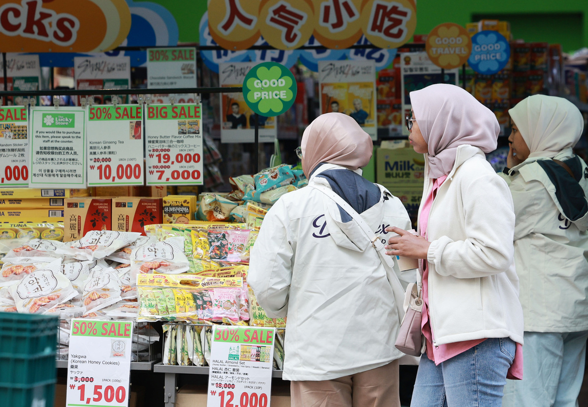 Иностранцы выбирают корейские продукты питания на улицах Мёндона в Сеуле, 20 октября (Ренхап)
