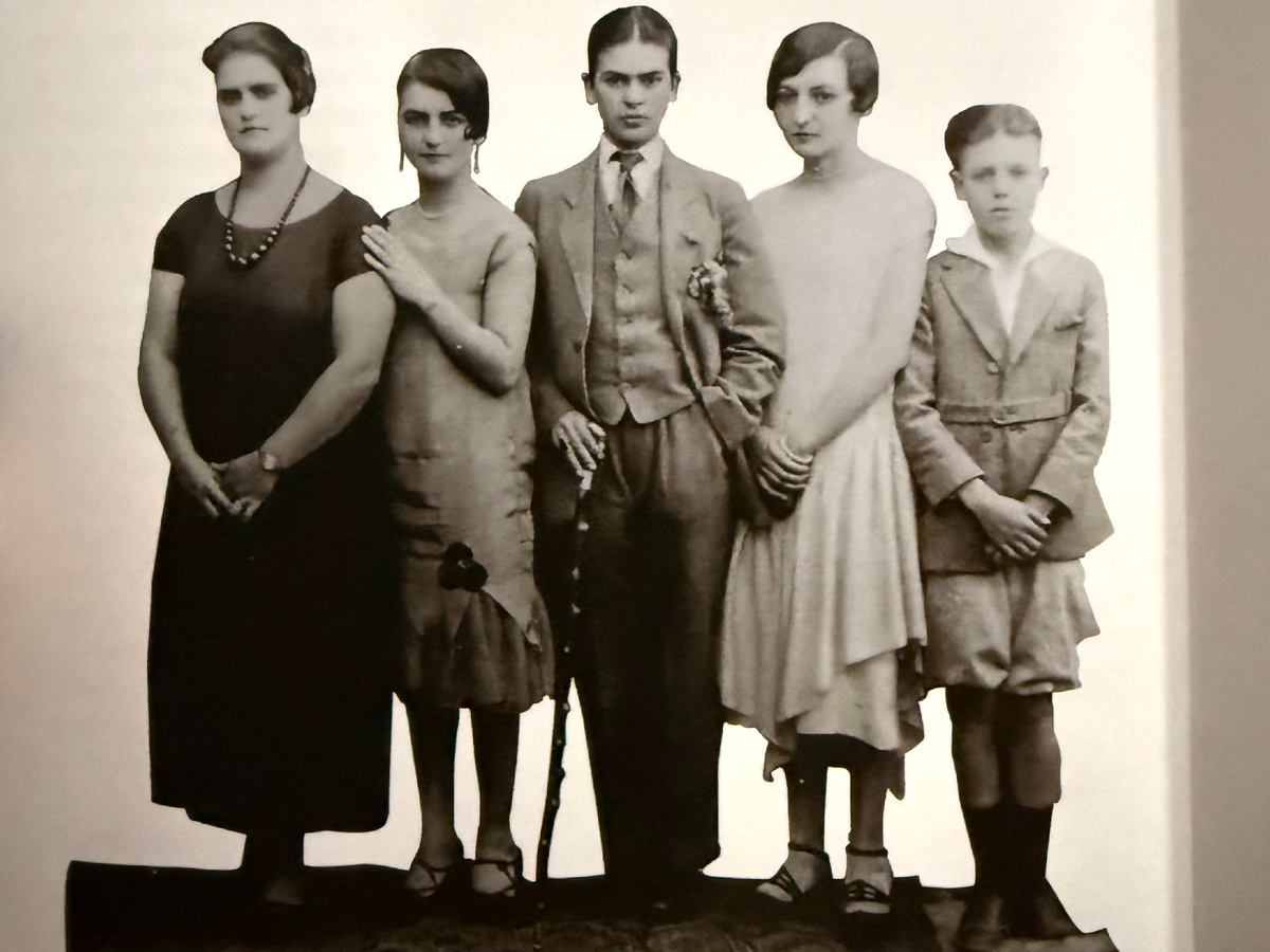 Редкая фотография Фриды (в центре) из книги Viva la Фрида. Снимок сделан уже после аварии, а мужской стиль и трость выдают в ней воина, готового побороться за свою жизнь.