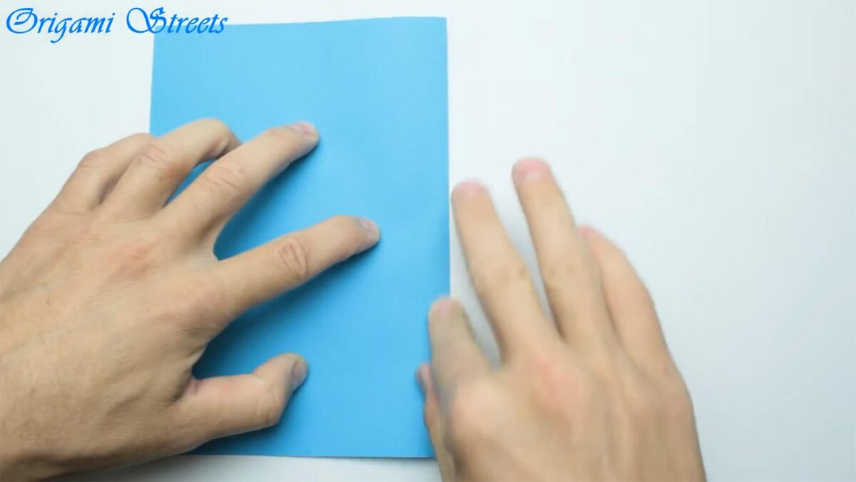    Сложите лист бумаги пополам, пригладьте крайOrigami Streets / YouTube