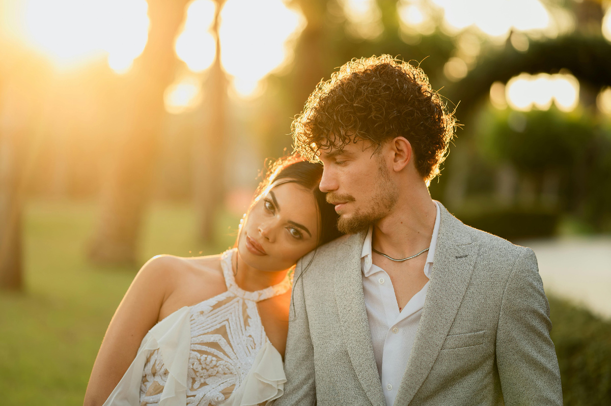 Девушка с нежностью опирается на плечо парня во время заката, символизируя доверие и близость