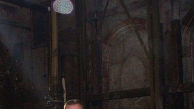 На этом старом фото я в Иерусалиме в Храме Гроба Господня, рядом с Кувуклией. На фото видно, как луч света падает на голову, а сверху получился светлый ореол — что-то вроде "короны" на снимке. Возможно это оптический эффект от освещения и особенностей камеры, но вероятно и как  символический знак.