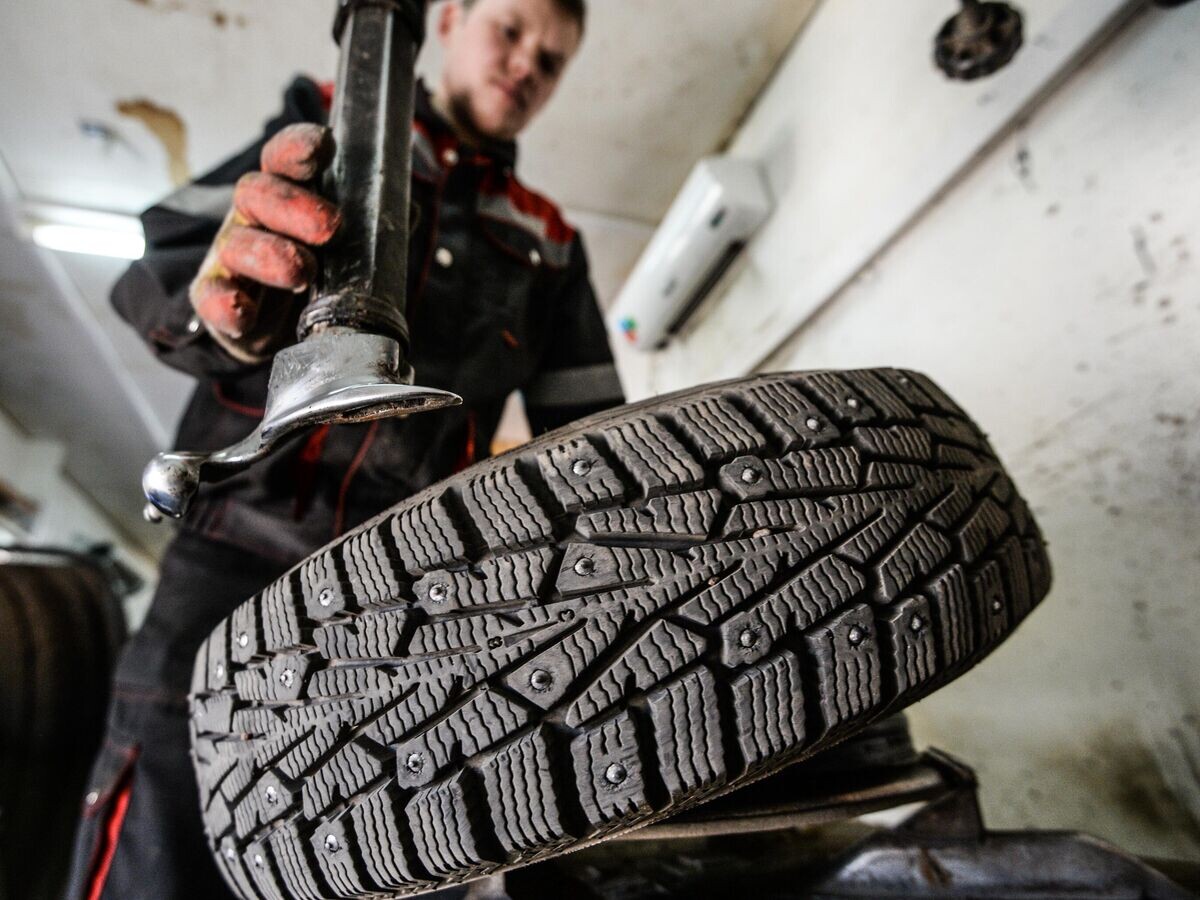    Работник меняет резину на колесе © РИА Новости / Константин Чалабов