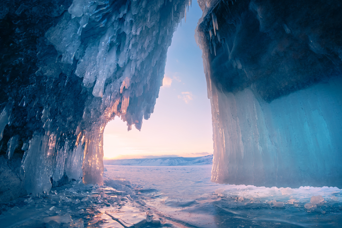 Ледяная пещера с сосульками на озере Байкал на закате. Зимний пейзаж озера Байкал, Сибирь, Россия. Источник фото: shutterstock.com