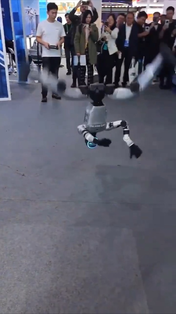 Китайский робот выполняет комплекс ушу и крутит боковое сальто.