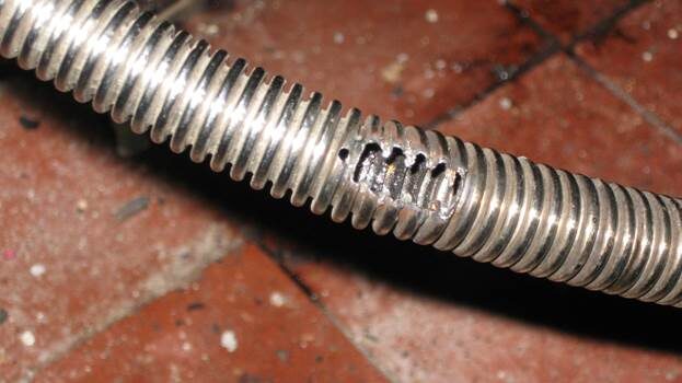 Сильфонный металлорукав, прожженный насквозь из-за того, что на трубе газопровода без электроизолирующего соединения возникло электрическое напряжение. 