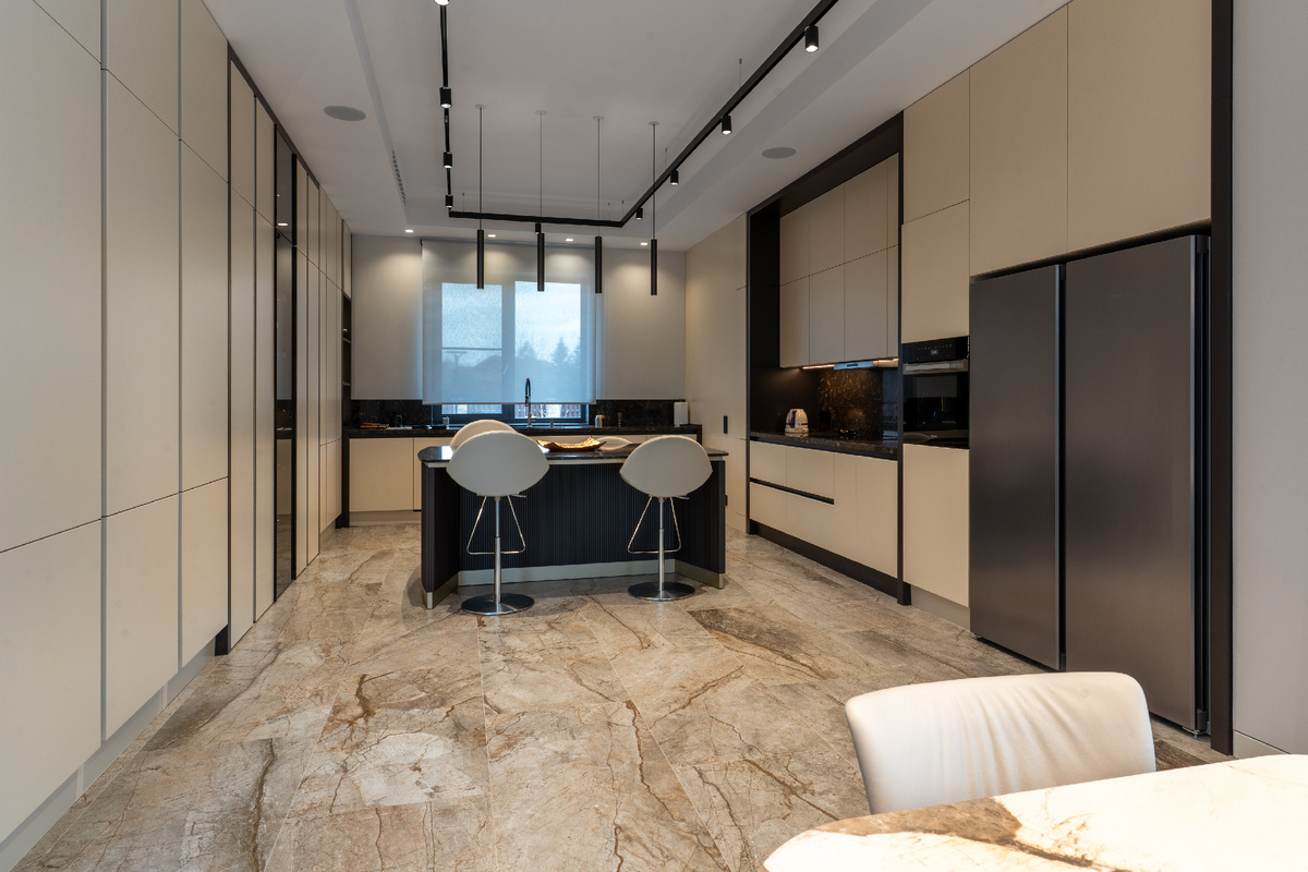 Просторная кухня четко зонирована на зоны для приготовления пищи и для семейных трапез