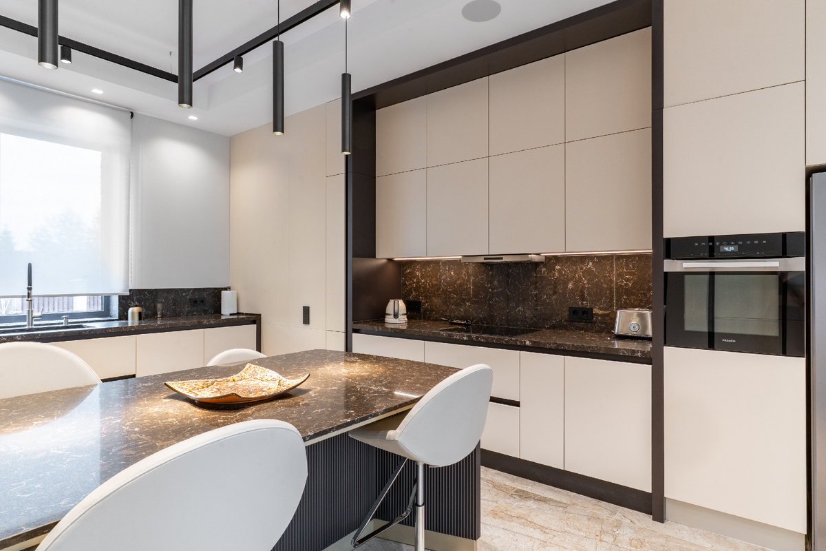 Просторная кухня четко зонирована на зоны для приготовления пищи и для семейных трапез