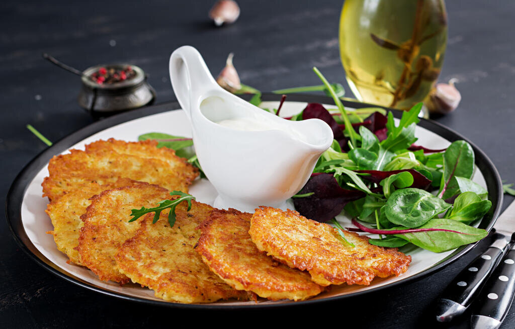   Potato fritters/draniki/pancakes served with sour cream. European cuisine. Kosher eating. Vegan food. Журналист