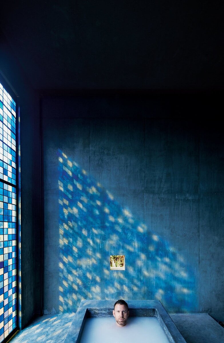 Ванная комната с высоким изогнутым потолком, окрашенными в синий цвет стенами и камином