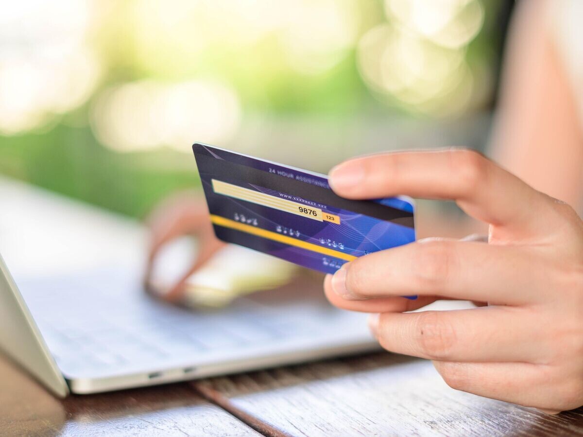    Девушка с ноутбуком и банковской картой© iStock.com / PATTRAWUT
