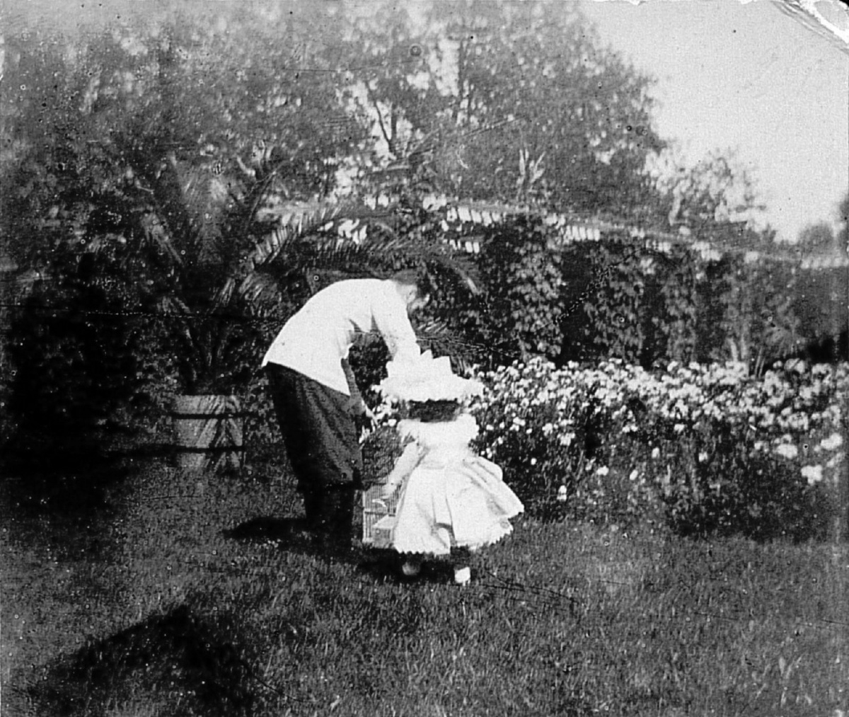 Николай показывает ребенку клетку с птицами