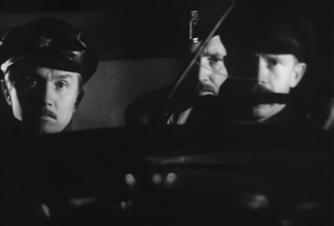 Два милиционера и шофёр-бандит сидят в салоне машины.