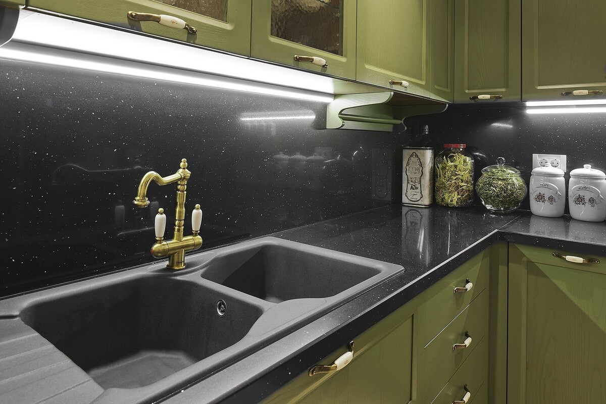 Черная столешница из кварцевого камня 5751 Gala Black Belenco в комбинации с зелеными фасадами кухни