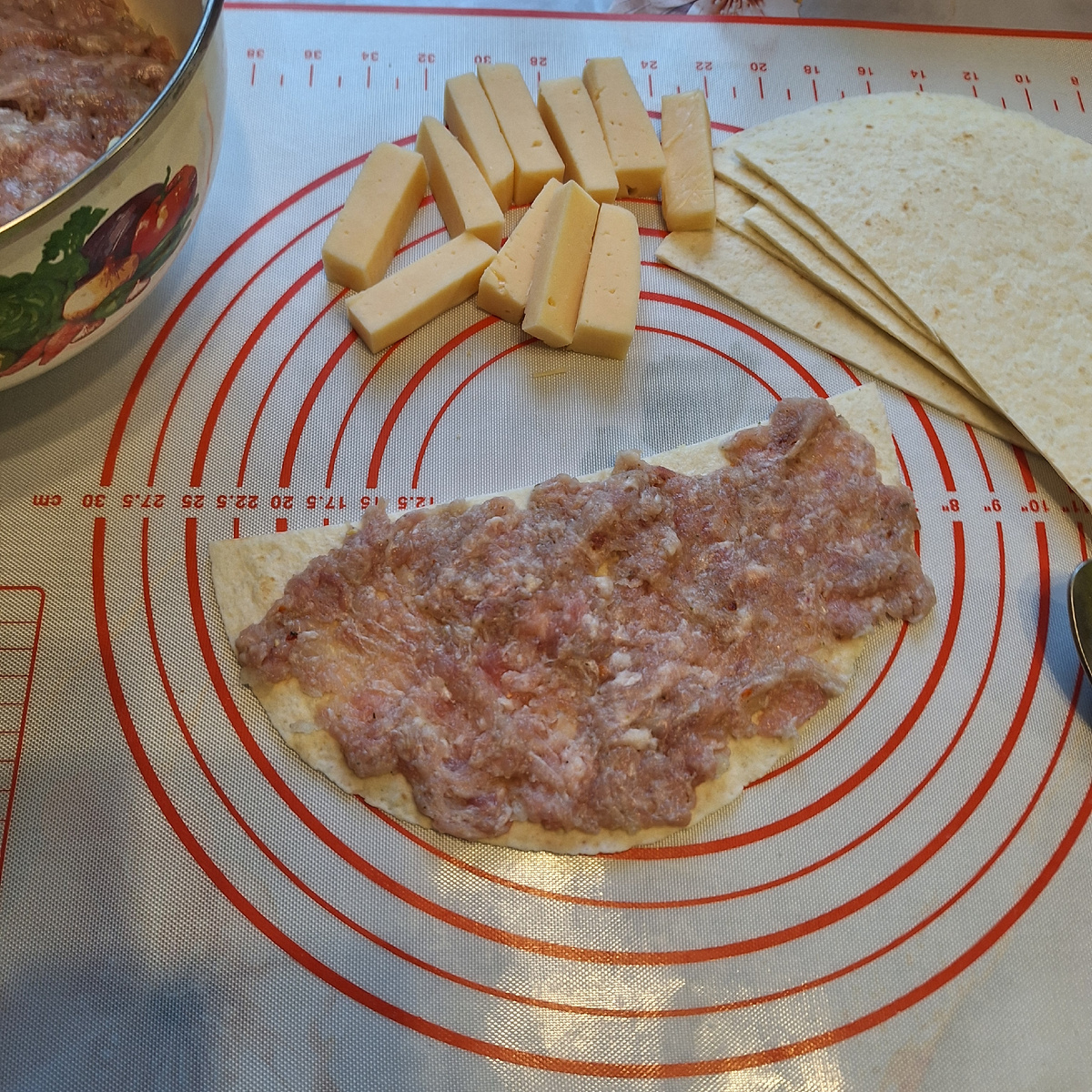 Свернуть  заготовки конусом и в каждую вставить брусочек твёрдого сыра. Поставить вертикально в форму для запекания.