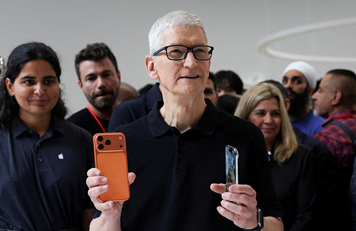    Тим Кук держит iPhone 17 Pro и iPhone Air на презентации гаджетов в Купертино, Калифорния. Сентябрь, 2025 годаREUTERS/Manuel Orbegozo