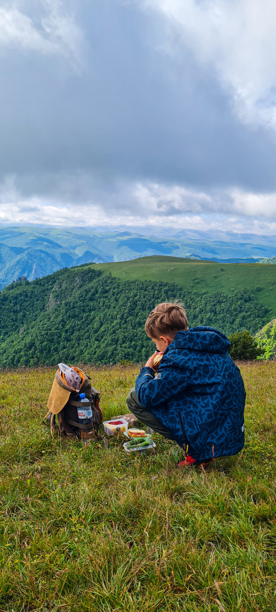 Привал: чай, бутерброды на фоне красивого горного пейзажа.