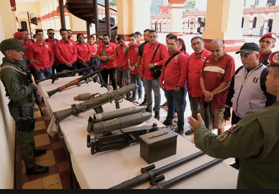 Сотрудник президентской гвардии демонстрирует оружие новым добровольцам из гражданской милиции во время общенациональной кампании по набору в Каракасе, Венесуэла. (Ариана Кубильос/AP)