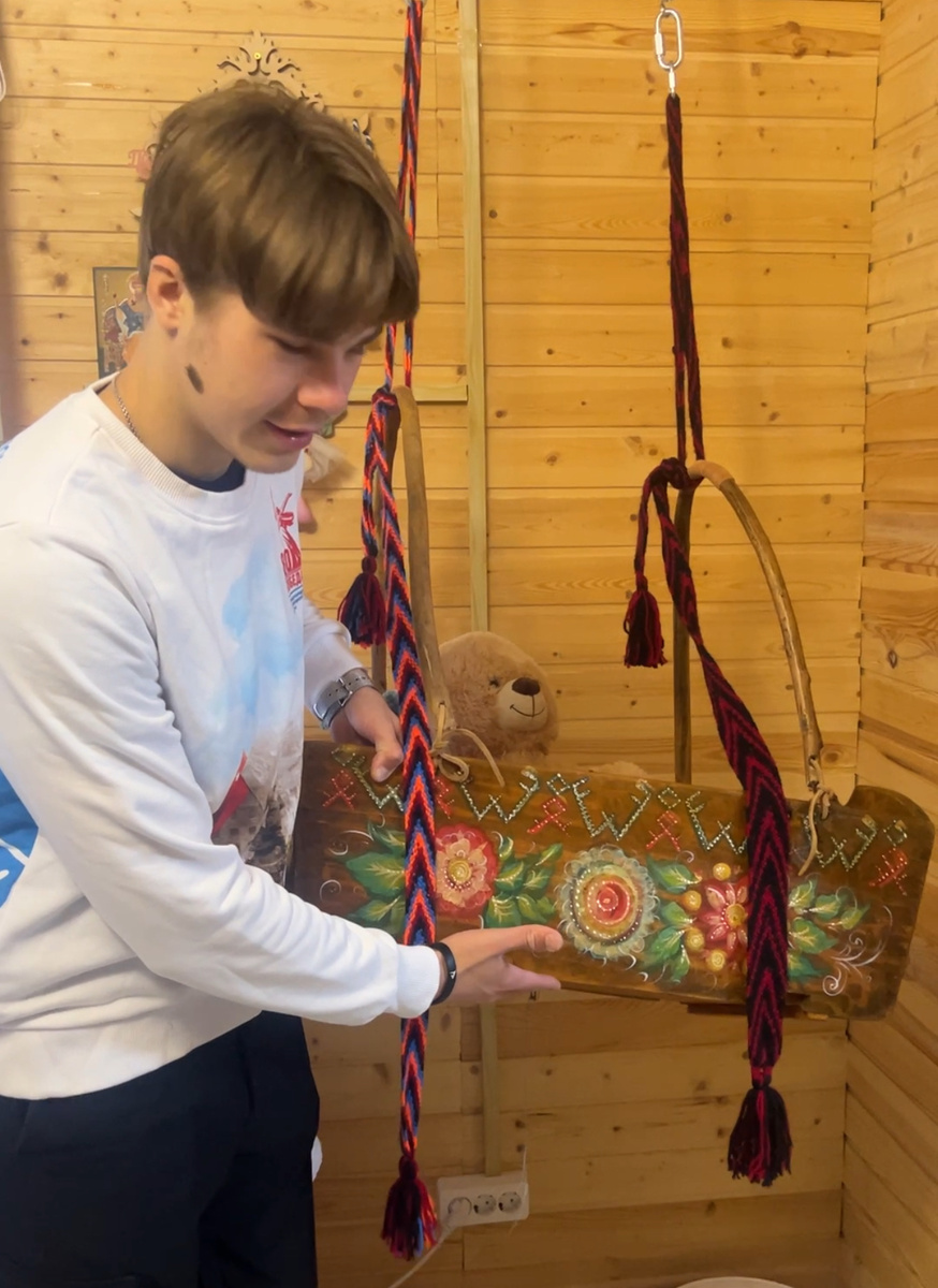 Автор рассматривают старую люльку (зыбку)