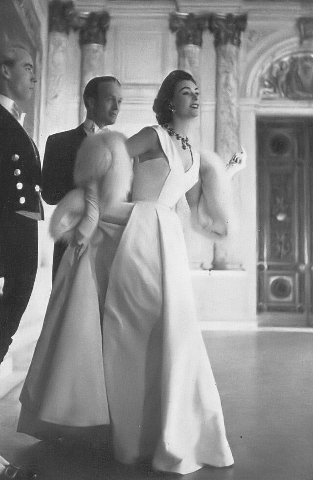 Энн Ганнинг в белом шелковом бальном платье из репсовой ленты, ниспадающем гладкими складками, от Джона Каванаха, в накидке-палантине из белой лисицы от National Fur Co., фото Ричарда Дормера, Harper's Bazaar UK, июнь 1953 г.