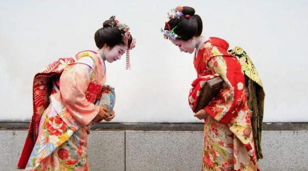 Достаточно низко кланяться, чтобы не смущать отвечающего поклоном, тоже гири