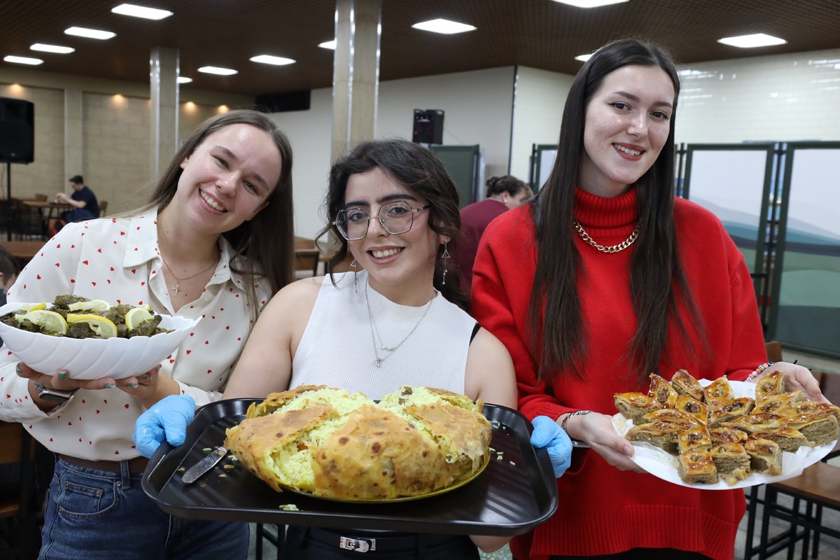 Участницы кулинарных соревнований с блюдами национальной кухни