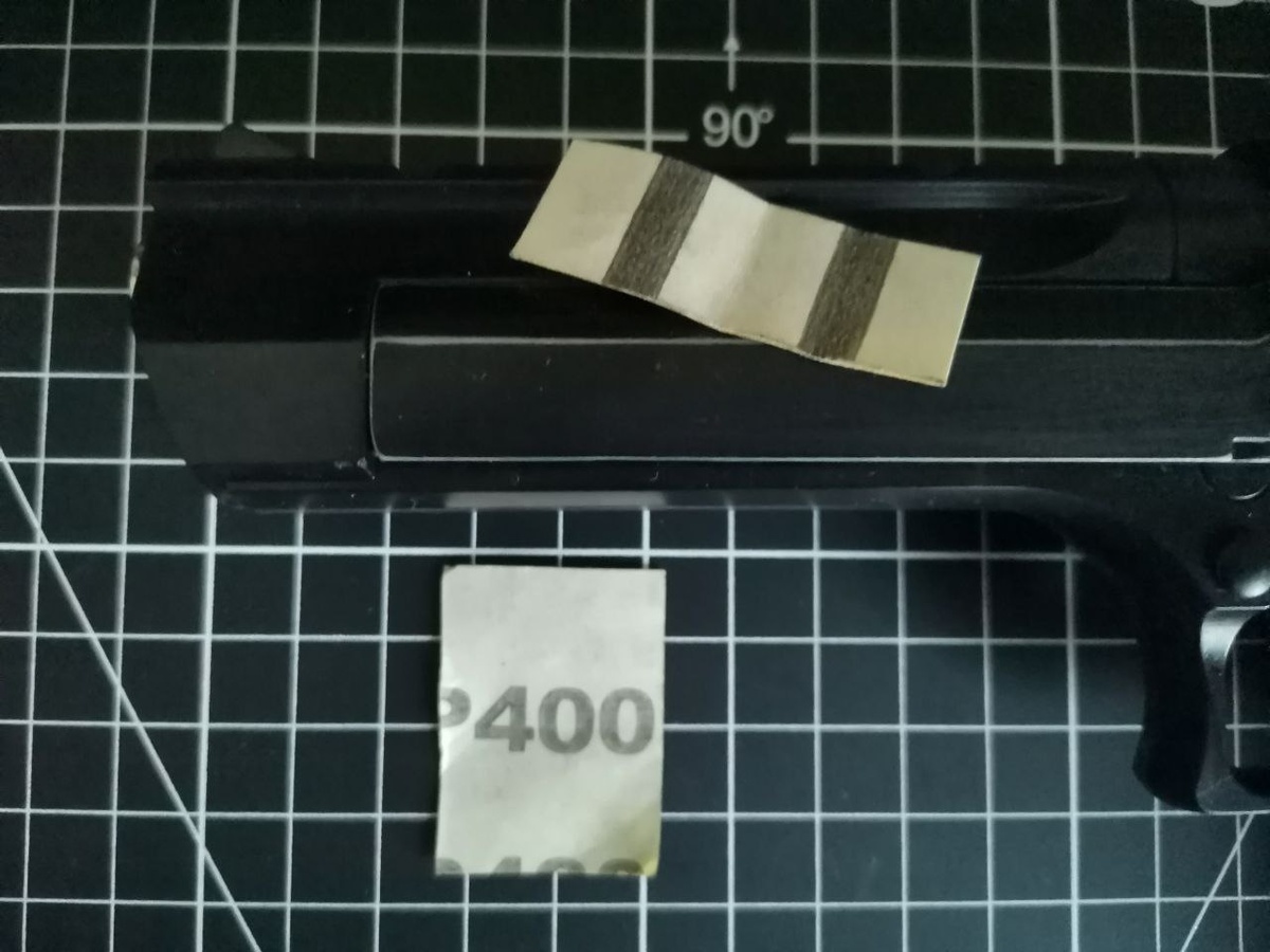 Берём наждачную бумагу средней зернистости, что-нибудь типа Р400 и начинаем проходить ей грани пистолета, стирая краску