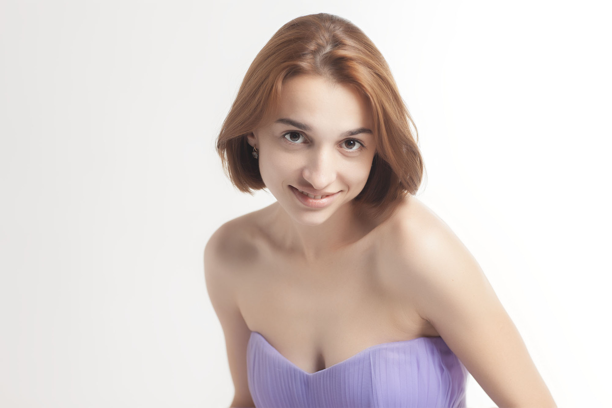 Девушка смотрит прямо в глаза зрителя с некоторым вызовом, но в целом, ее взгляд выражает живой интерес, но не агрессию.