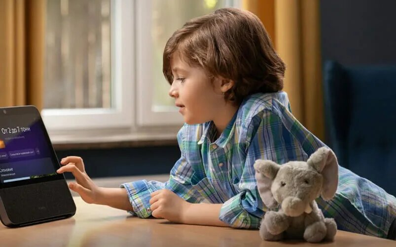 Ребенок увлеченно играет с голосовым помощником