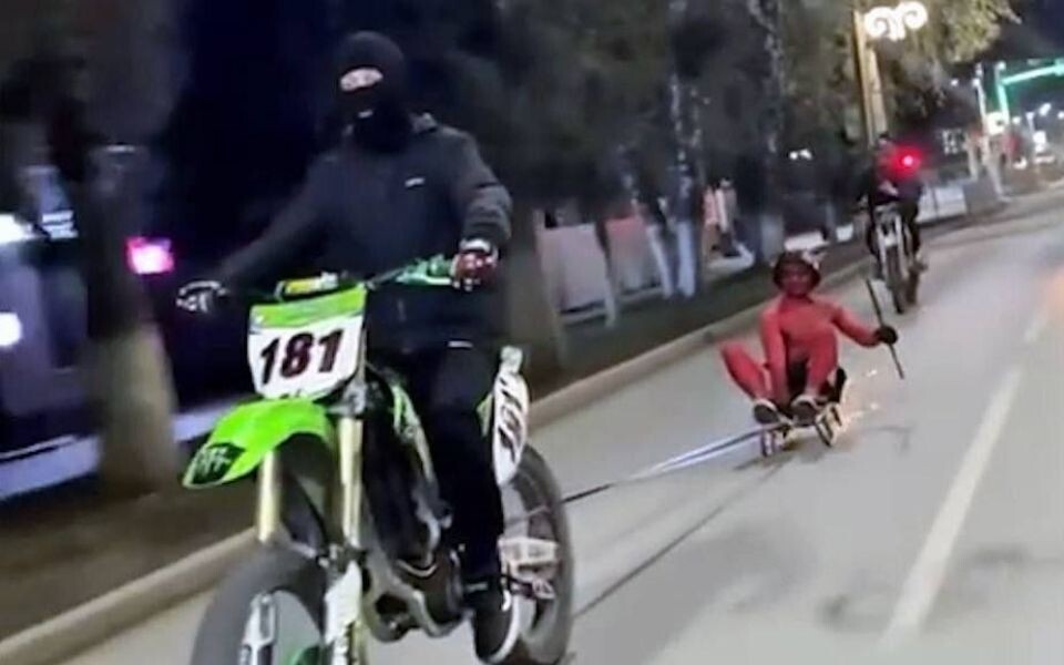    Мотоциклист везет участника челленджа от Мелстроя