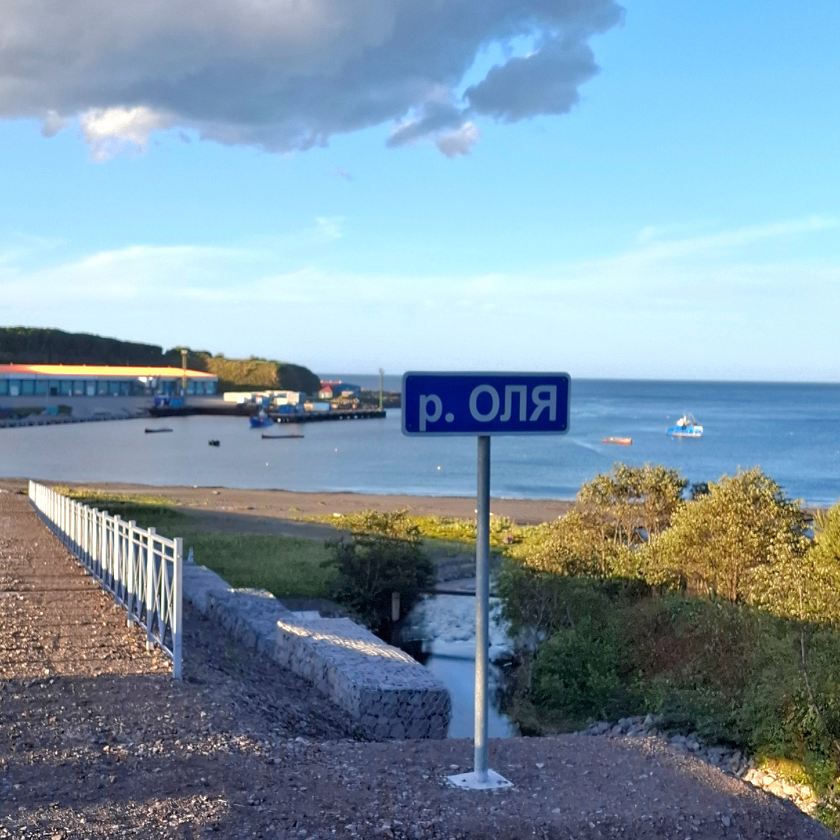 Бухта Оля, с айнского переводится как «копыто», на заднем плане рыбзавод. Верхняя тропа уходит вверх слева от него. Фото автора.