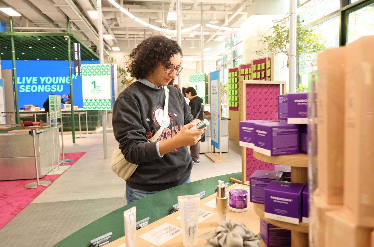 Иностранный посетитель рассматривает продукцию корейской косметики во флагманском магазине CJ Olive Young в районе Сонсу-дон на востоке Сеула. (CJ Olive Young) 