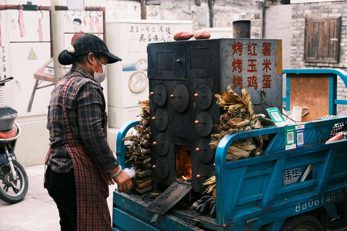 Традиционное лакомство  женщина готовит жаренные яйца кукурузу и сладкую картошку батат Хоншу 