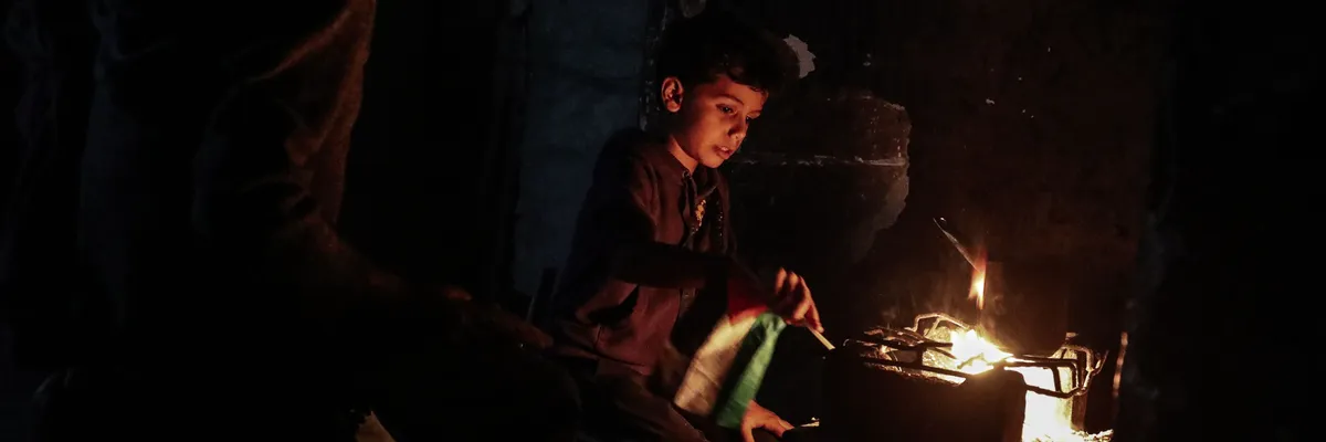 Палестинцы борются со тьмой, продолжая свою повседневную жизнь в суровых условиях, среди темных улиц и разрушенных зданий в лаборатории Бурейдж, Бурейдж, расположенной в центральной части сектора Газа, 12 ноября 2025 года. (Фото Моиза Салхи/Anadolu через Getty Images)