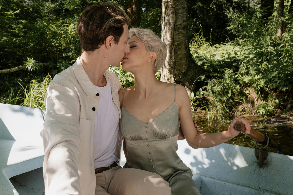 Пара целуется в лодке во время романтической прогулки