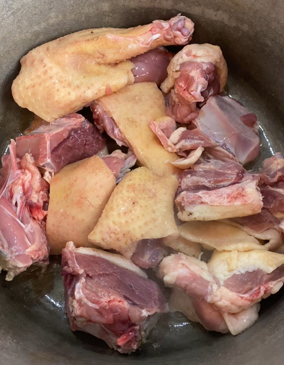 Положить части утки в казан.