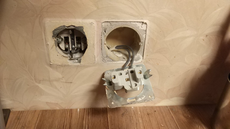 [Фотография механизма розетки, вытащенного из стены]