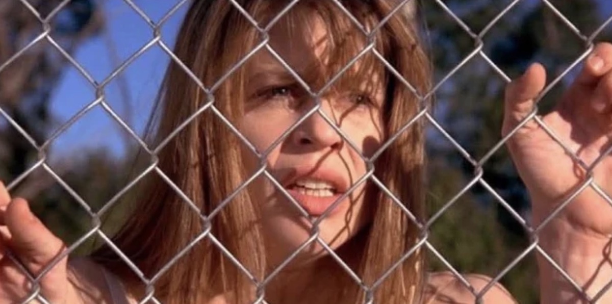 Сара Конор в Терминаторе стоит у забора из рабицы, наблюдая апокалипсис в своем сне