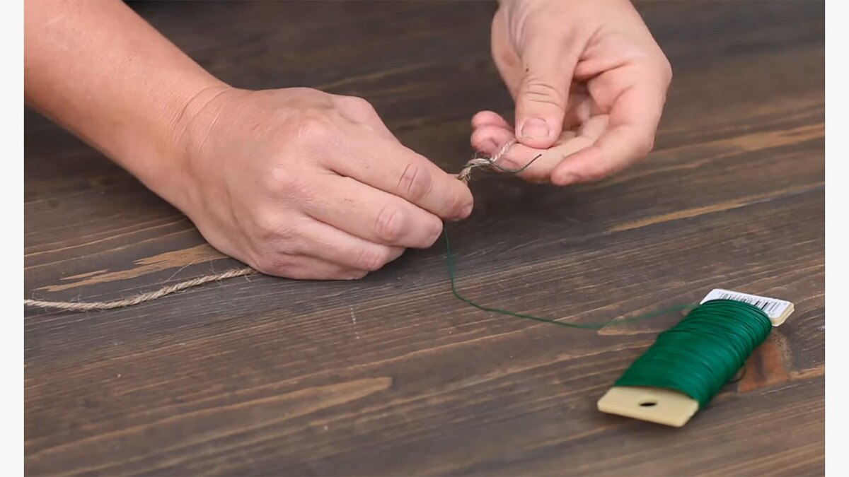    Шаг 1. Возьмите проволоку и обмотайте ею несколько сантиметров бичевки. Это будущий каркас для гирляндыGarden Answer Highlights / YouTube