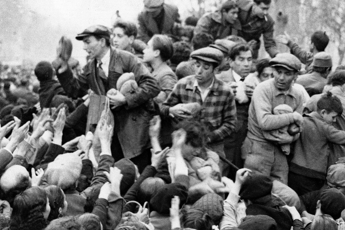   Раздача хлеба голодающим жителям Барселоны после входа в город мятежных войск под командованием генералиссимуса Франсиско Франко. Январь 1939 года. 
AP