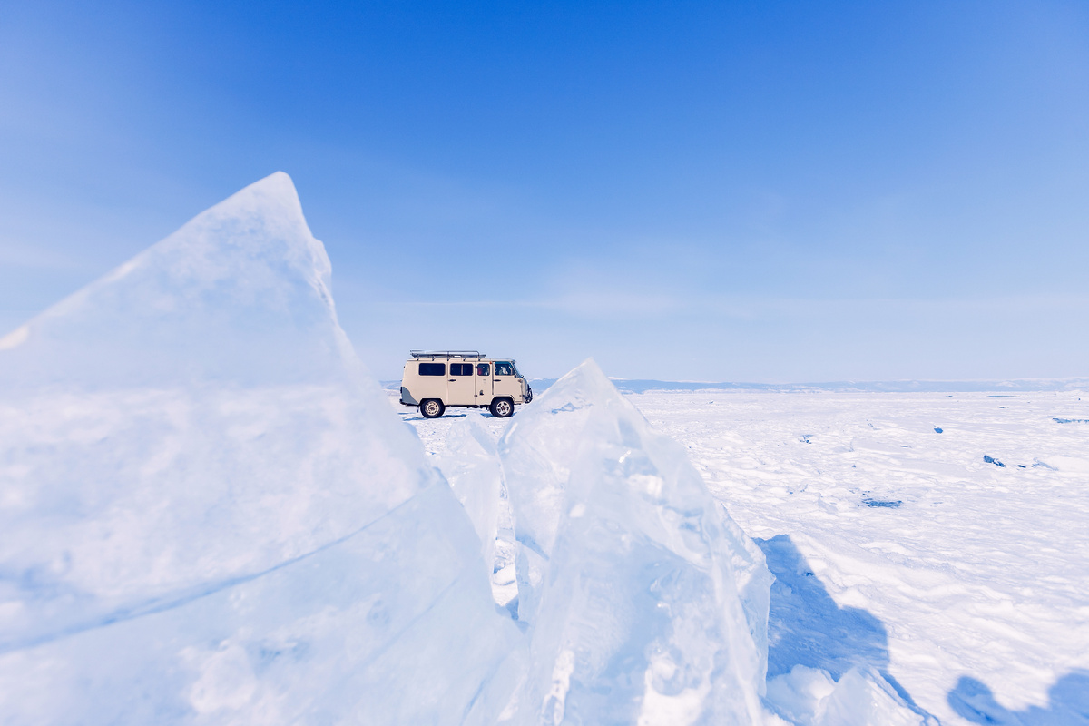 Туристический автобус на фоне замороженного льда озера Байкал. Источник фото: shutterstock.com