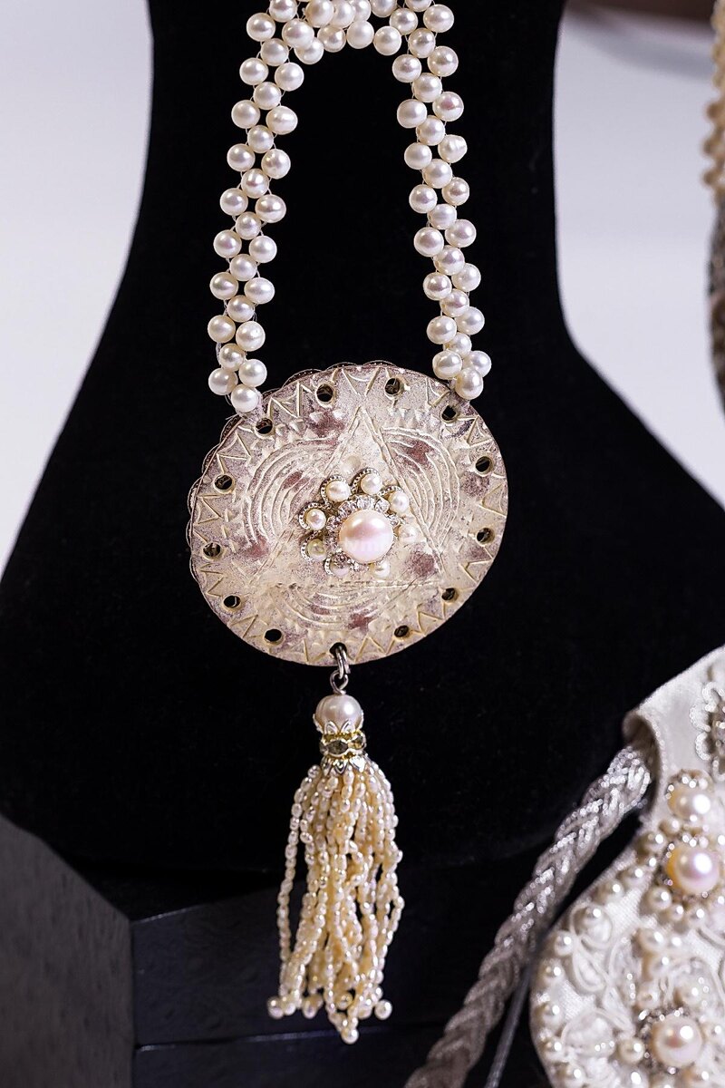 Височные кольца в Древней Руси часто заменяли серьги, и были распространенным украшением славянских женщин. Эта коруна украшена вышивкой — росшив жемчугом и стразами. Жемчужные рясны венчают височные кольца, которые можно носить на две стороны: одна сторона колец украшена перламутровым узором, вторая сторона сканью с жемчугом. Источник фото: https://slavmoda.com/product/koruna-anastasiya/