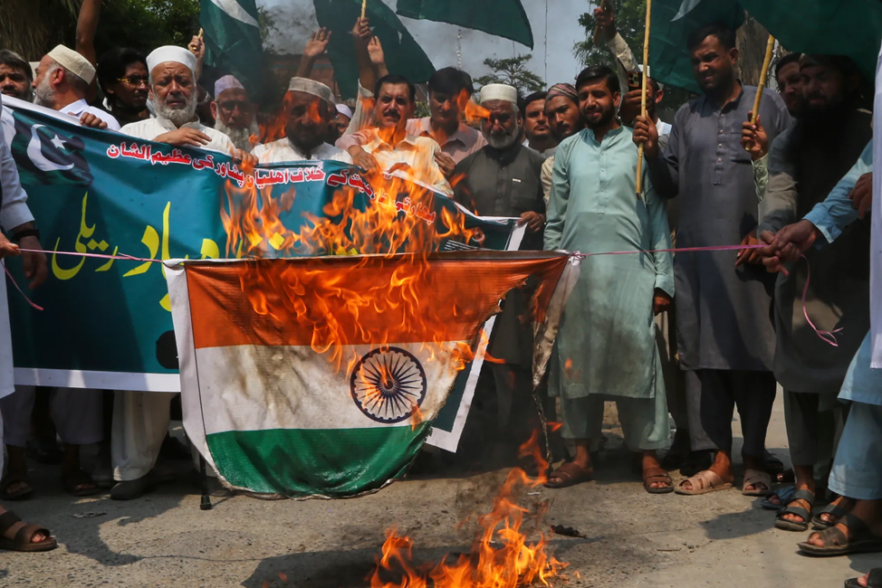 Пакистанцы сжигают флаг Индии и прославляют свою армию во время индо-пакистанского конфликта 