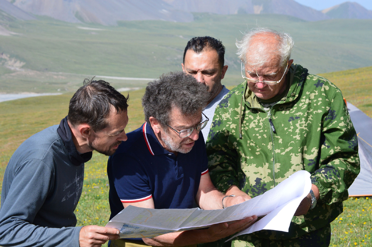 М. А. Преснков, А. В. Семёнов-Тян-Шанский, А. Н. Капитанов и Н. С. Попов в ходе обсуждения нах картой местности в 2015г. в базовом лагере в долине Сарыджаза. Фото рязанского музея путешественников. 