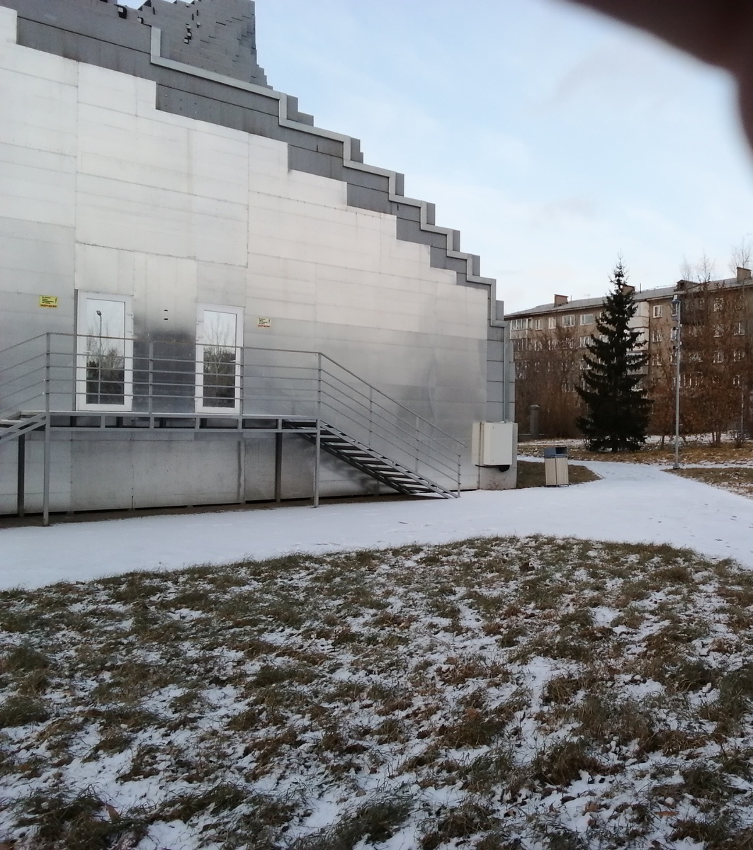 Вон тот белый ящик около лестницы.