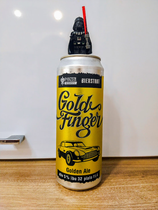 На этикетке ни Джеймса, ни Голдфингера нет. Зато есть Астон Мартин DB5, на котором Бонд рассекал в фильме. В книге же была более старая модель - DB3